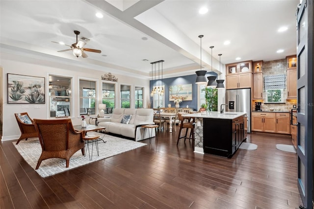 living area with ceiling fan, dark wood-type flooring, a raised ceiling, and recessed lighting