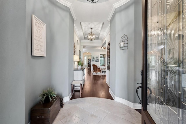 entryway with baseboards, ceiling fan with notable chandelier, arched walkways, and crown molding