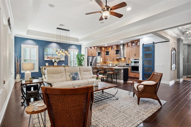 living area with ornamental molding, a barn door, a raised ceiling, and visible vents