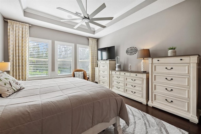 bedroom with a raised ceiling, crown molding, dark wood-style flooring, and ceiling fan