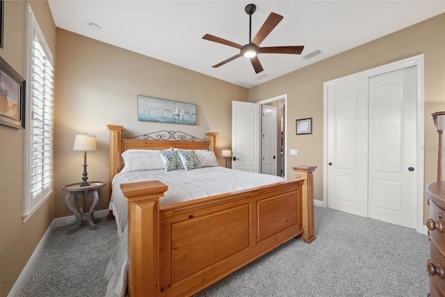 bedroom with a closet, visible vents, light carpet, ceiling fan, and baseboards