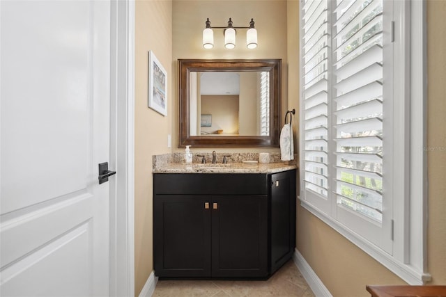 bathroom featuring tile patterned flooring, baseboards, and vanity