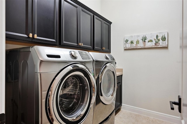 laundry area featuring washer and dryer, cabinet space, baseboards, and light tile patterned floors