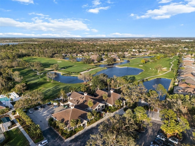 drone / aerial view featuring a residential view, view of golf course, and a water view