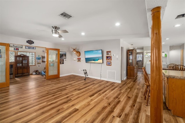 living area featuring recessed lighting, visible vents, baseboards, and light wood-style flooring