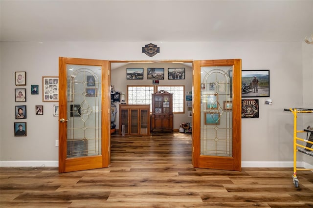 foyer featuring wood finished floors, baseboards, and french doors