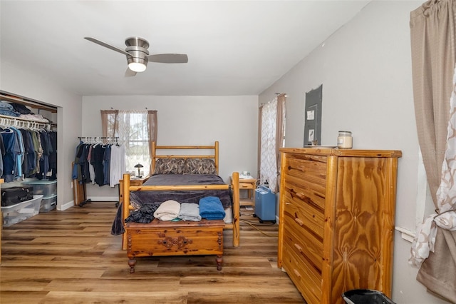 bedroom with a closet, baseboards, ceiling fan, and wood finished floors