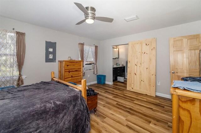 bedroom featuring visible vents, baseboards, cooling unit, light wood-style floors, and a ceiling fan