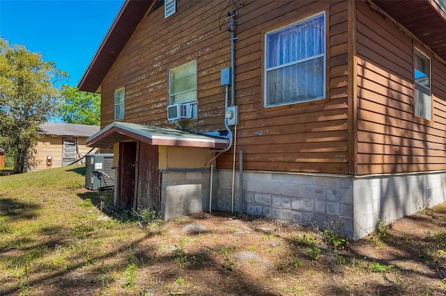 view of property exterior featuring crawl space, a lawn, and cooling unit