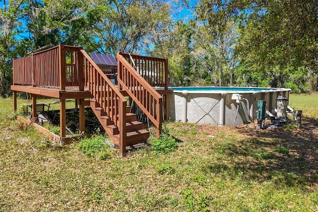 view of yard with an outdoor pool, a wooden deck, and stairs