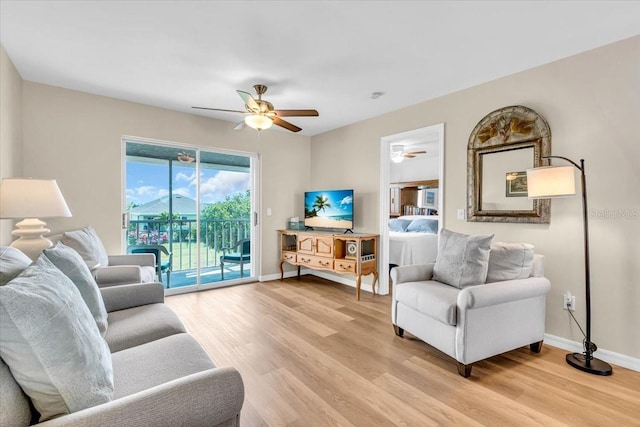 living area featuring light wood-style floors, ceiling fan, and baseboards