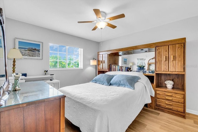 bedroom with light wood-style flooring, baseboards, and a ceiling fan