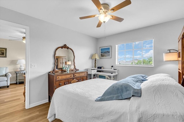 bedroom featuring ceiling fan, light wood-type flooring, and baseboards