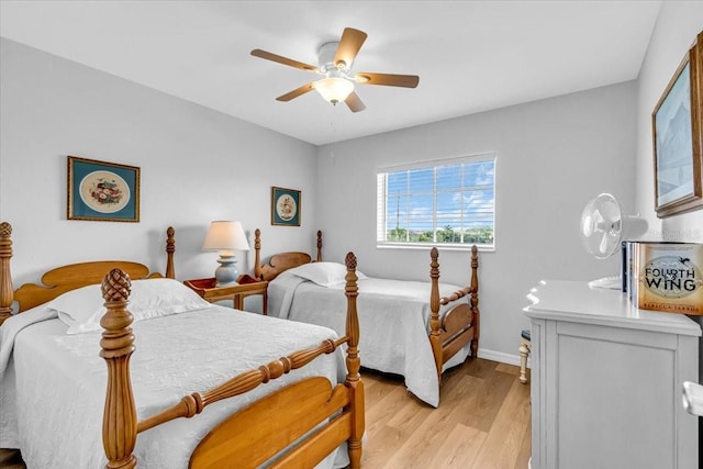 bedroom with a ceiling fan, light wood-style flooring, and baseboards