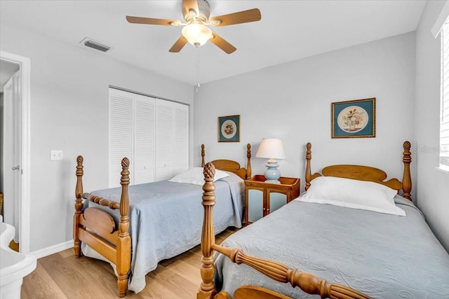 bedroom featuring a closet, visible vents, a ceiling fan, light wood-type flooring, and baseboards