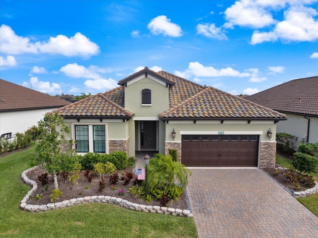 mediterranean / spanish home with a garage and a front lawn