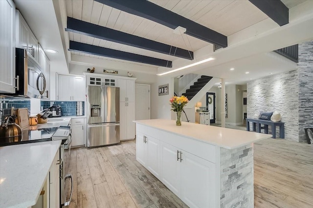 kitchen featuring light wood-style floors, tasteful backsplash, stainless steel appliances, and light countertops