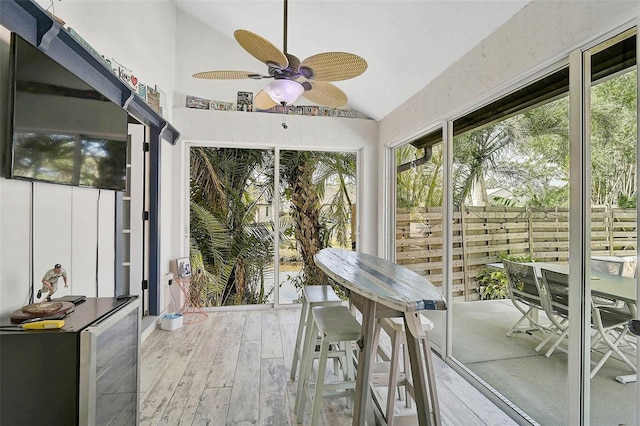 unfurnished sunroom featuring vaulted ceiling and a ceiling fan