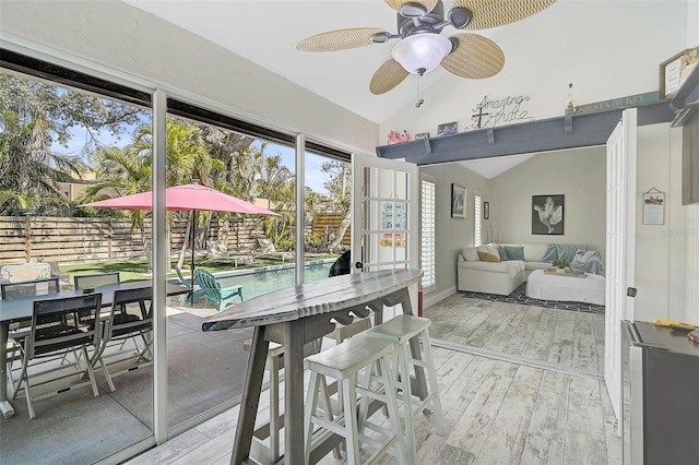 sunroom with lofted ceiling and a ceiling fan