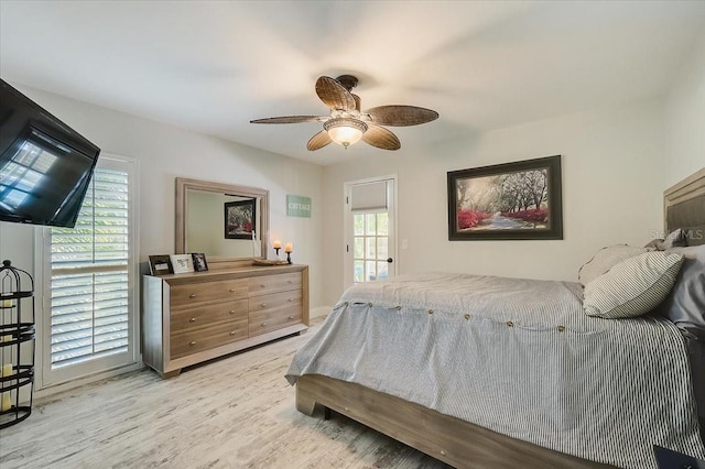 bedroom with ceiling fan, multiple windows, and wood finished floors