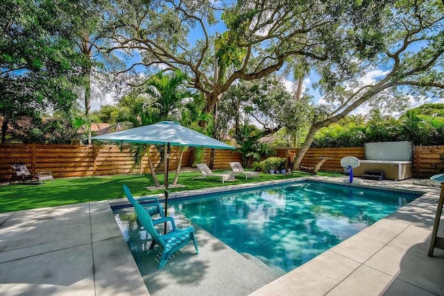 view of pool featuring a patio area, a hot tub, a lawn, and a fenced backyard