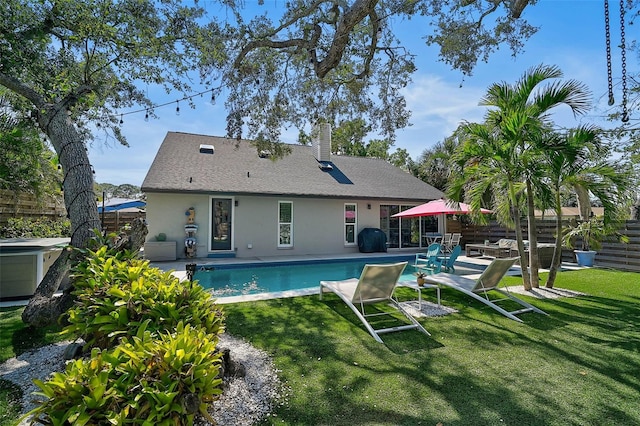 back of house with a yard, a patio, stucco siding, fence, and an outdoor pool