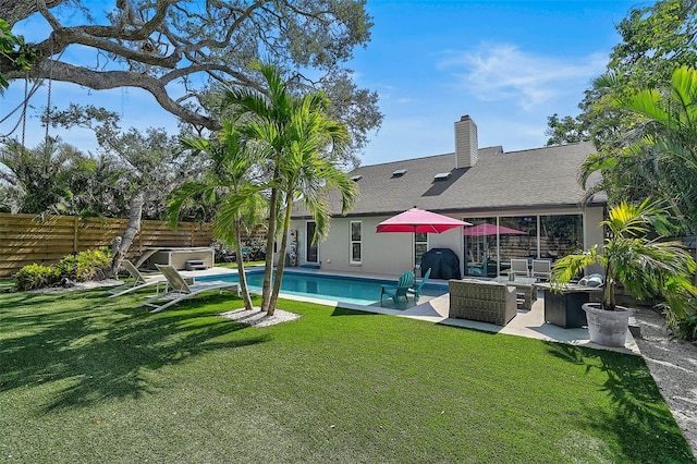 back of property with an outdoor hangout area, a yard, fence, and a hot tub