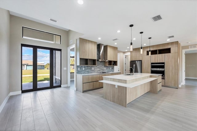 kitchen with a kitchen island with sink, light countertops, and modern cabinets