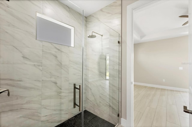 full bathroom with a stall shower and baseboards