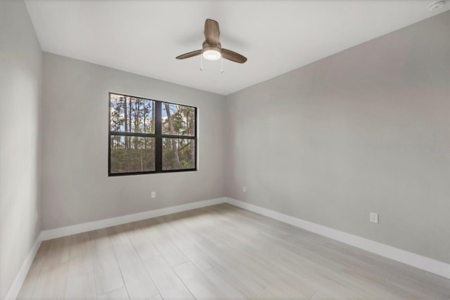 unfurnished room with light wood-type flooring, baseboards, and a ceiling fan