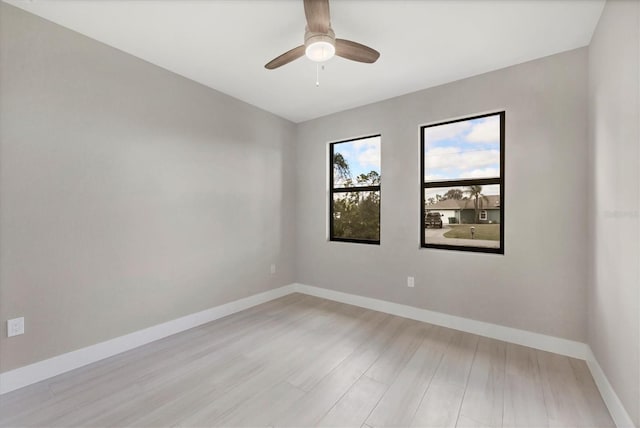 unfurnished room with light wood-style floors, a ceiling fan, and baseboards