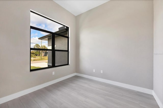 empty room featuring light wood-type flooring and baseboards