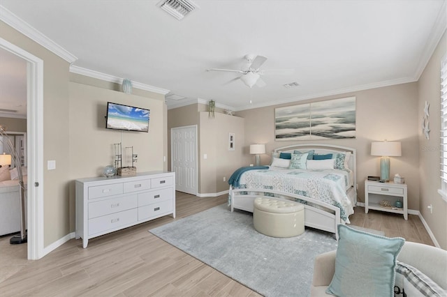 bedroom with baseboards, light wood-type flooring, visible vents, and crown molding