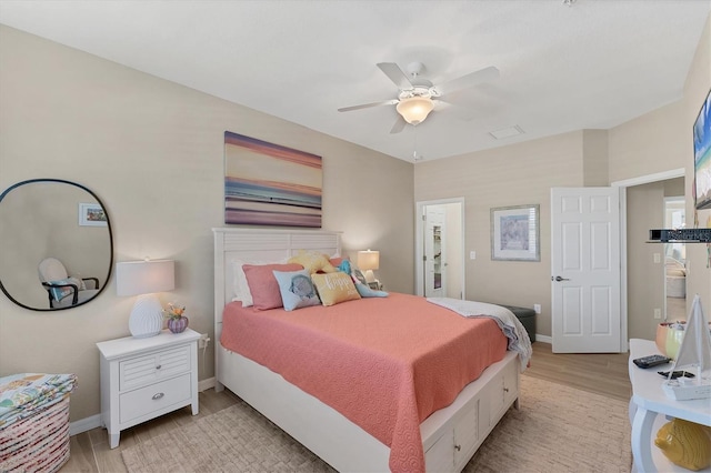 bedroom with a ceiling fan, light wood-style flooring, and baseboards