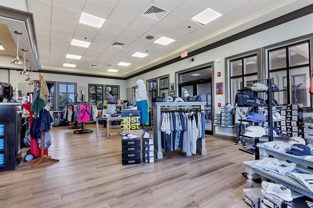 exercise room with a drop ceiling, wood finished floors, and visible vents