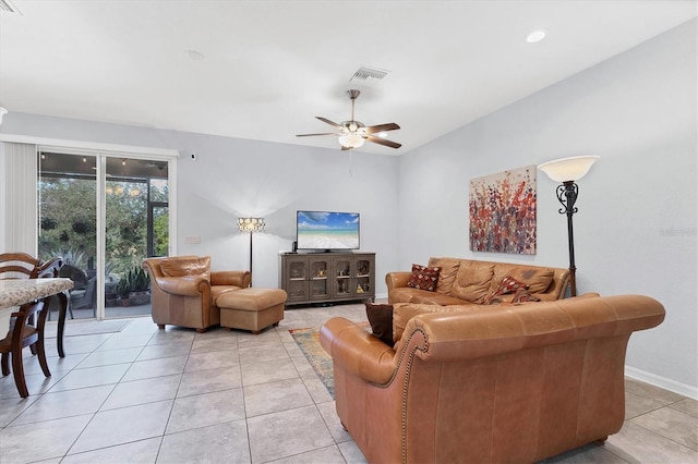 living area featuring ceiling fan, light tile patterned flooring, visible vents, and baseboards