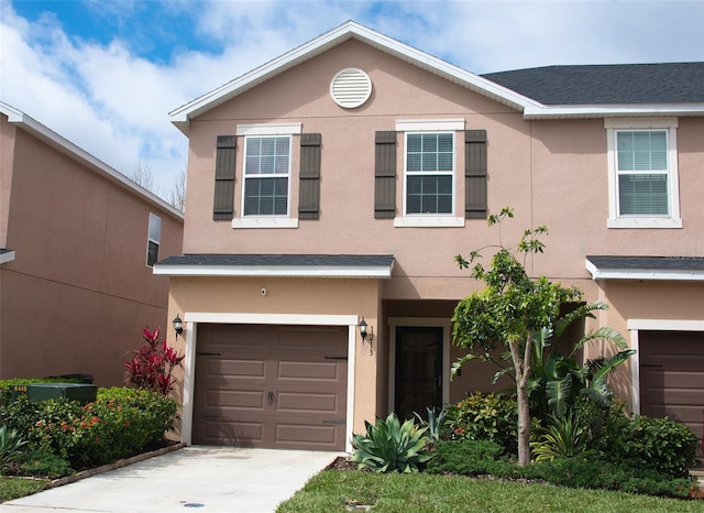 view of front of home with driveway, an attached garage, and stucco siding