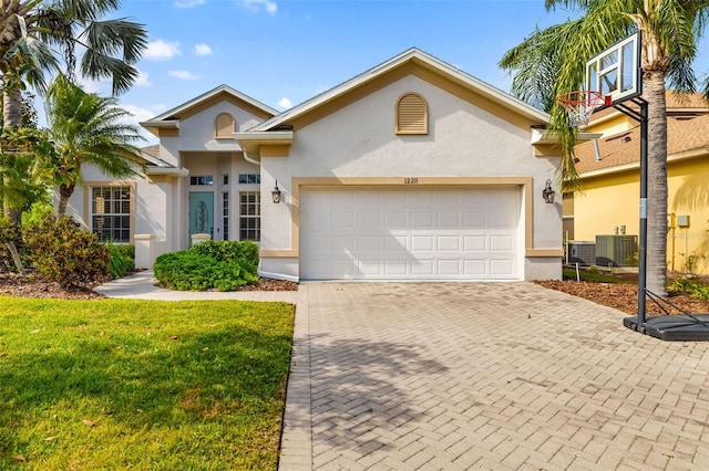 12211 Lavender Loop, Bradenton, FL 34212 - view of front of house featuring stucco siding, decorative driveway, an attached garage, and a front yard