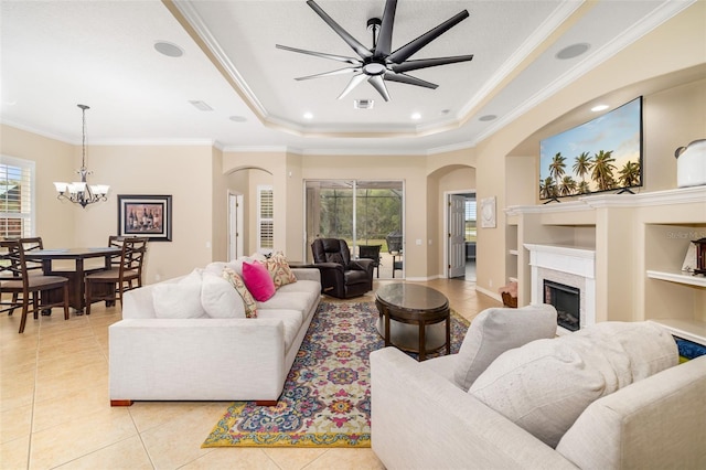 12211 Lavender Loop, Bradenton, FL 34212 - living room featuring healthy amount of natural light, a raised ceiling, a chandelier, light tile patterned flooring, and crown molding