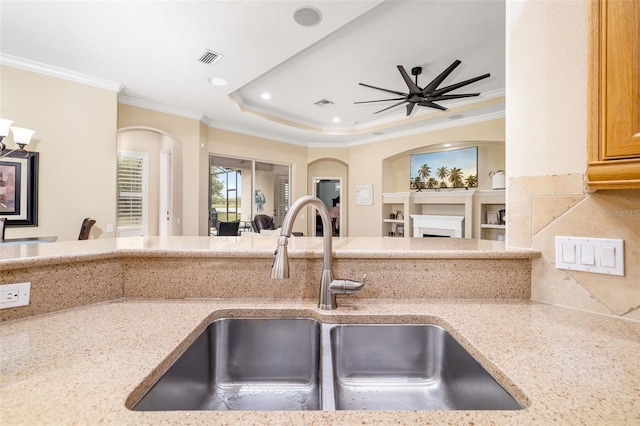 12211 Lavender Loop, Bradenton, FL 34212 - kitchen with a sink, open floor plan, crown molding, a fireplace, and light stone counters
