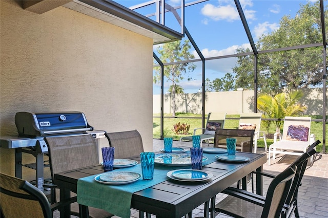 view of patio with glass enclosure and a grill