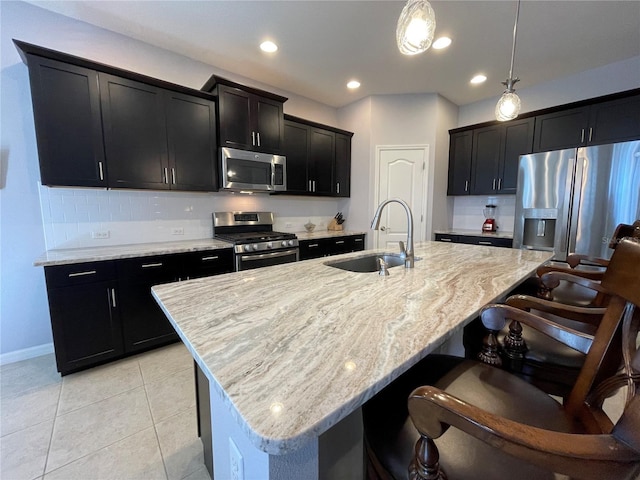 kitchen with sink, stainless steel appliances, an island with sink, and pendant lighting