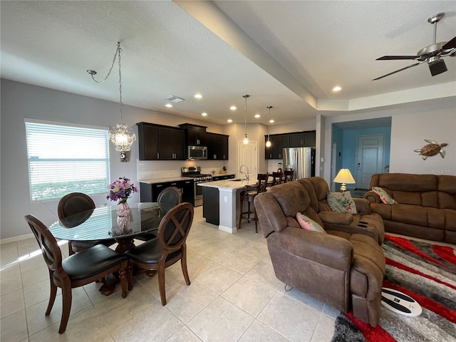 dining room featuring a textured ceiling, sink, ceiling fan, and light tile patterned floors