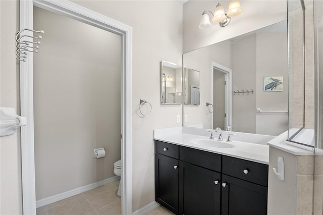 bathroom with toilet, vanity, and tile patterned flooring