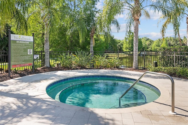 view of pool featuring a hot tub and a water view