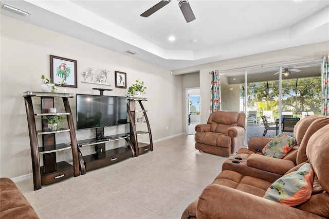 tiled living room featuring a tray ceiling and ceiling fan