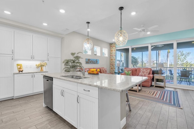 kitchen featuring wood finish floors, white cabinets, a sink, and dishwasher