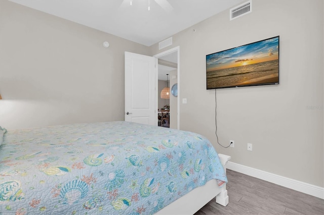 bedroom with visible vents, ceiling fan, baseboards, and wood finished floors