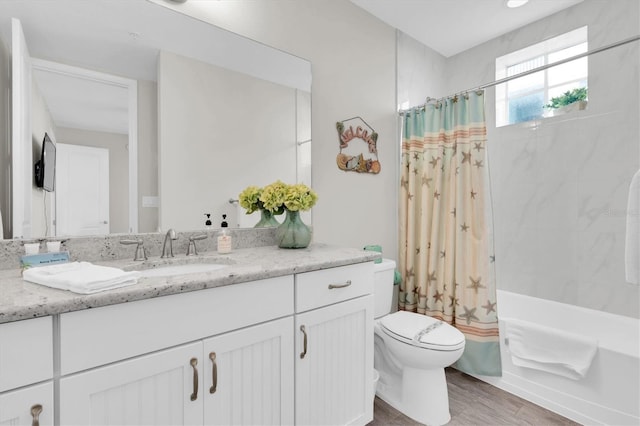 bathroom featuring toilet, shower / bathtub combination with curtain, wood finished floors, and vanity