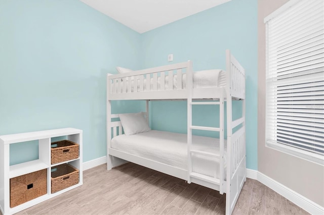 bedroom with baseboards and wood finished floors